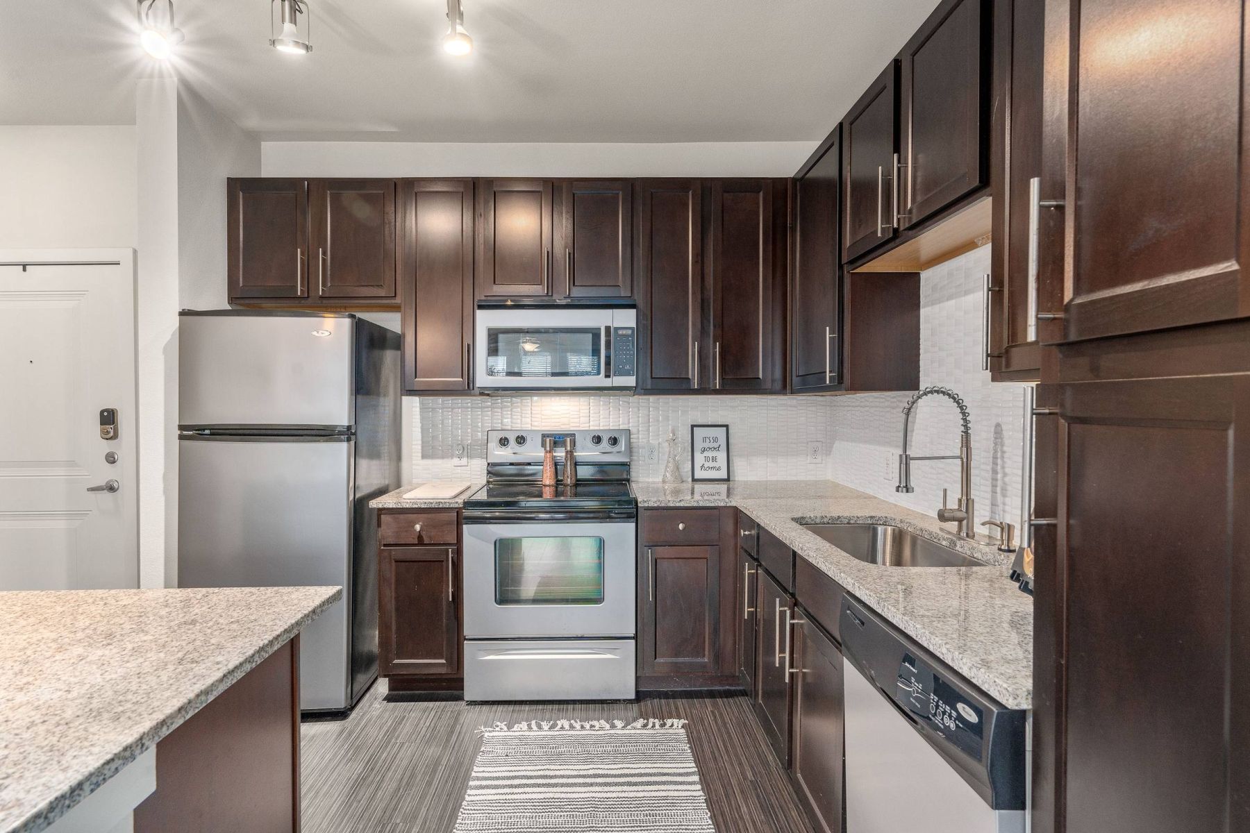 Luxury apartment kitchen with stainless steel appliances, granite countertops, and lots of storage space